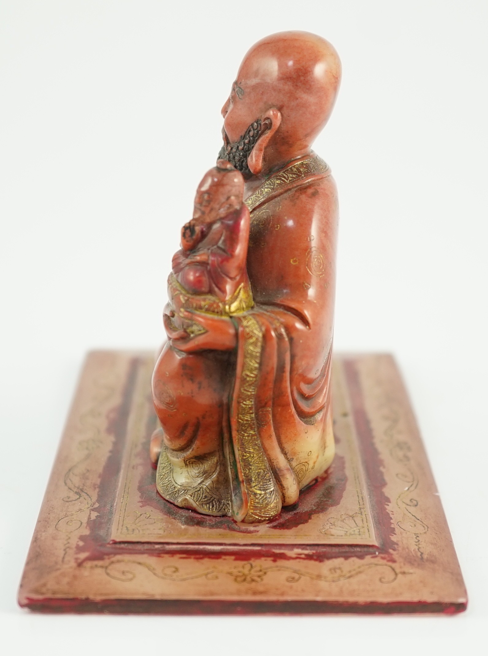 A Chinese soapstone group of a luohan holding a figure of Buddha, 18th century, 12cm wide, 9cm high